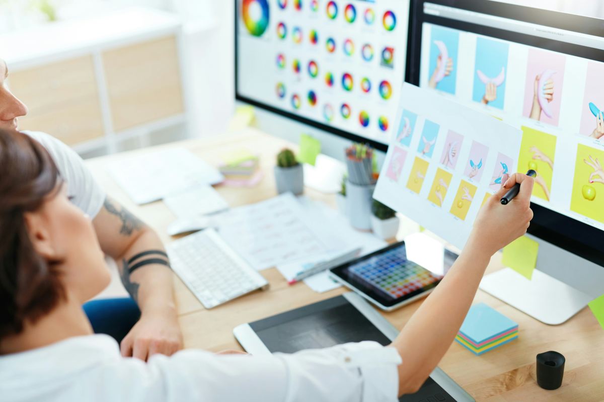 A designer reviewing colour studies and layouts on a large screen