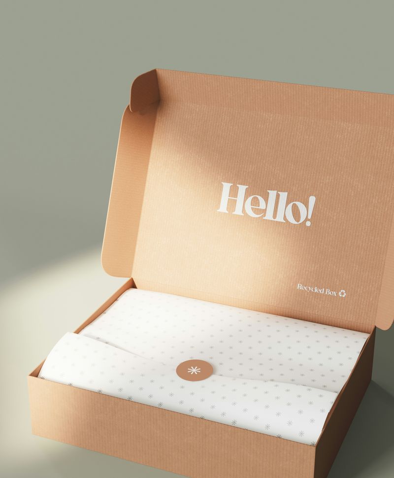 An open kraft mailer box printed with Hello
